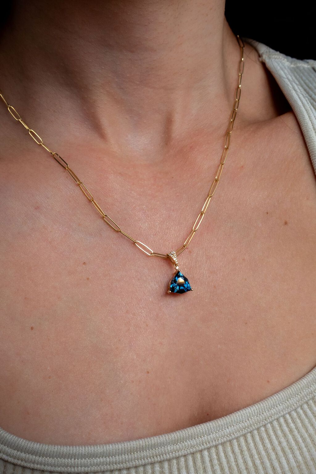  Woman wearing a beautiful blue gemstone pendant on a paperclip chain